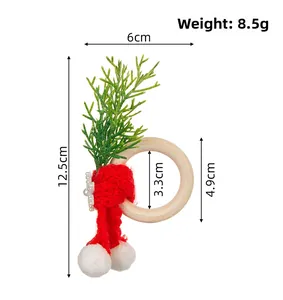 Dettaglio portatovagliolo di Natale con sciarpa rossa a maglia, perline e ramo verde