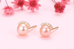 Close-up of pink freshwater pearls with curved zirconia accents on gold studs