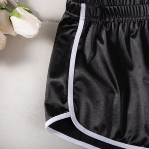 Detail of high-elastic black yoga shorts with white contrast trim and side slit