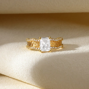 Macro shot of gold ring with large rectangular zircon and wavy textured diamond band