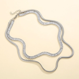 Close-up of double-layer silver necklace with flat snake chain and rectangle crystal