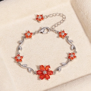 Detailansicht eines Luxus-Armbands mit orangefarbenen Zirkonia-Blumen und Blättern