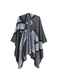 Detailed close-up of geometric floral jacquard texture on gray knit poncho shawl