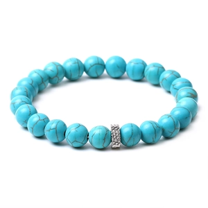 Detail of blue turquoise beaded bracelet with silver metal spacer bead on white background