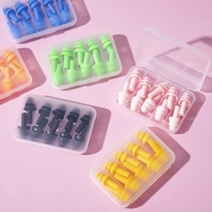 Macro view of six pairs of colorful silicone earplugs in clear plastic cases for sleeping