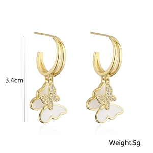 Detail view of 18K gold butterfly hoop earrings with white enamel and crystals, 3.4cm length