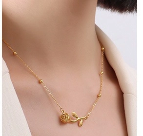 Detail of a 18k gold rose pendant necklace with small beads on a minimalist chain