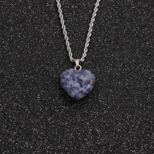 Detail of a heart-shaped blue and white stone pendant on a silver twisted chain