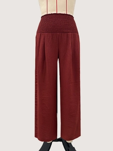 Détail du pantalon large rouge foncé à taille haute avec taille froncée et texture plissée