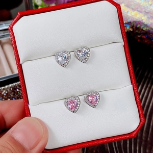 Detailed close-up of pink and white heart-shaped halo stud earrings set in a gift box