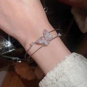 Detail of zircon butterfly double-layer open bracelet on wrist with lace sleeves