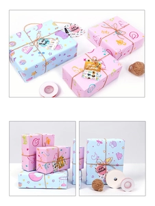 Close-up of baby-themed gift wrapping paper set with ribbons, twine, and tags
