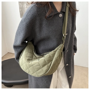 Vue détaillée du sac demi-lune matelassé vert olive avec bandoulière large réglable