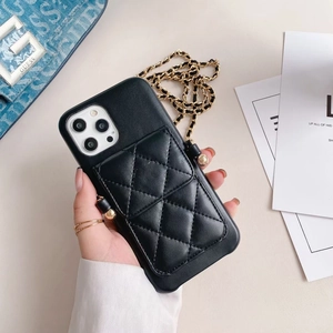 Detail of black quilted leather phone case with card slot and gold chain strap