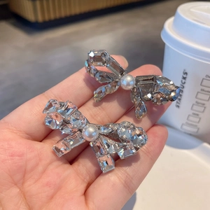 Elegant sparkling crystal bow hair clip with central pearl and silver metallic base