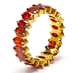 Detail of gold titanium ring featuring oval-cut dark red zircon stones in pavé setting