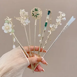 Close-up of various traditional Chinese hairpins with delicate gold and floral patterns