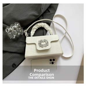 Detail of white crocodile pattern bag with crystal buckle and ruched handle