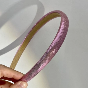 Close-up of glitter fabric pink headband showing detailed texture and soft lighting
