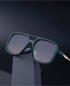 Detailed macro view of dark green acetate sunglasses frame with elegant gold metal hinge detail