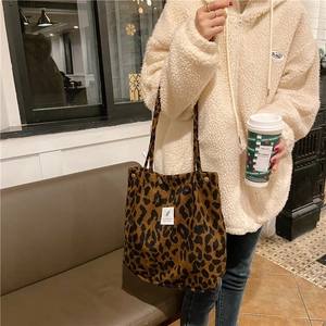 Bolso tote de pana con estampado de leopardo, cierres dorados y detalle de etiqueta