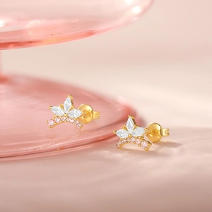 Macro shot of gold crown earrings with marquise stones and pink diamond details