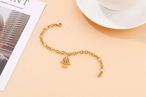Detailed view of a gold Hamsa hand pendant on a stainless steel chain with round links