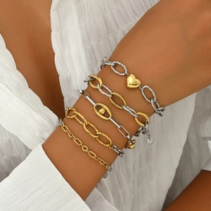 Detail of five-piece mixed link chain bracelet set with gold heart pendant on wrist