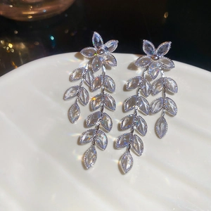 Detailed close-up of floral tassel earrings with sparkling zircon stones in a silver finish