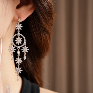 Detail of silver tassel earrings with zircon flowers and crystal teardrops on a model