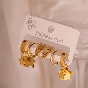 Gold stainless steel earring set with star, disc and leaf charms on display card