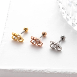 Macro shot of stainless steel butterfly tragus studs with zircon in gold and silver
