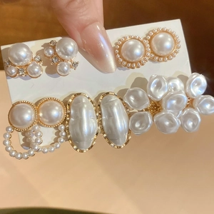 Detailed view of pearl hair clips set with gold metal settings and crystal accents