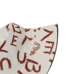 Dettaglio cuciture e stampa graffiti sul cappello alla pescatora in tela color crema