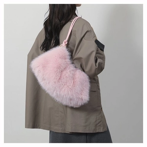 Détail du sac sous le bras en fausse fourrure rose avec texture douce et poignée nouée