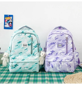 Detail showing mint green and lavender camo backpacks with cute white bear charms