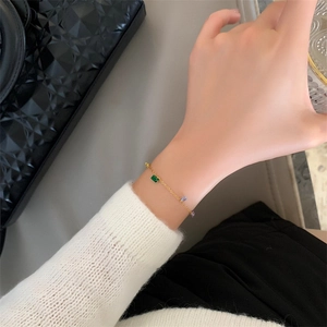Detail of a gold plated bracelet with colorful zircon stones on a female wrist