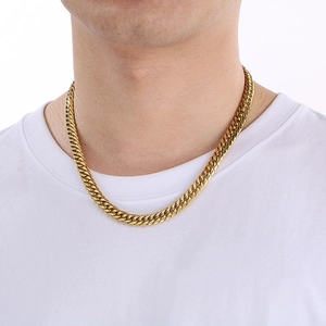Close-up of a model wearing a classic golden Cuban link chain necklace with high metallic luster