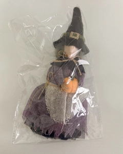 Detailed view of a purple witch doll hanging decoration in transparent plastic packaging