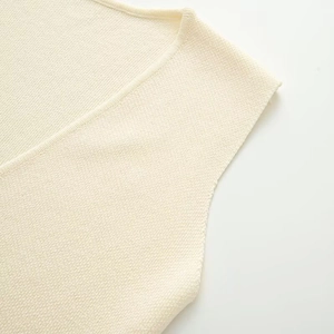 Detail of V-neckline and armhole on cream knitted vest with fine stitch texture