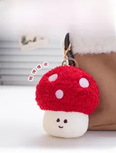 Close-up of red plush mushroom keychain with white dots and smile hanging on a bag