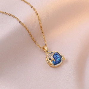 Macro detail of golden planet necklace with blue nebula pendant on pink silk