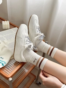 Detail of white mid-calf sports socks with retro stripes and Smile embroidery