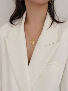 Golden 925 silver necklace with T-bar clasp and embossed round pendant on model