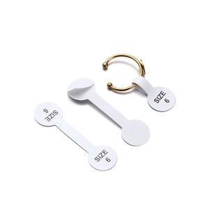 Detail shot of golden metal ring featuring a white dumbbell-shaped size 6 adhesive label