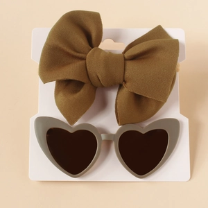 Detail of olive green knit bow headband and heart sunglasses on display card
