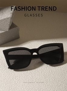 Macro view of black oversized square cat eye sunglasses with glossy frames on stone texture