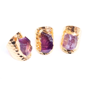 Three-piece set of gold hammered rings featuring raw purple amethyst natural crystals