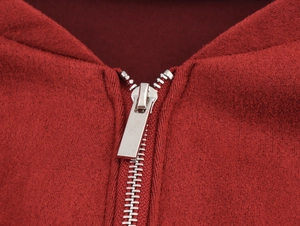 Close-up of the silver metal zipper and neckline on a red sleeveless knit maxi dress