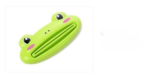 Macro detail of the green frog-shaped toothpaste squeezer showing plastic structure